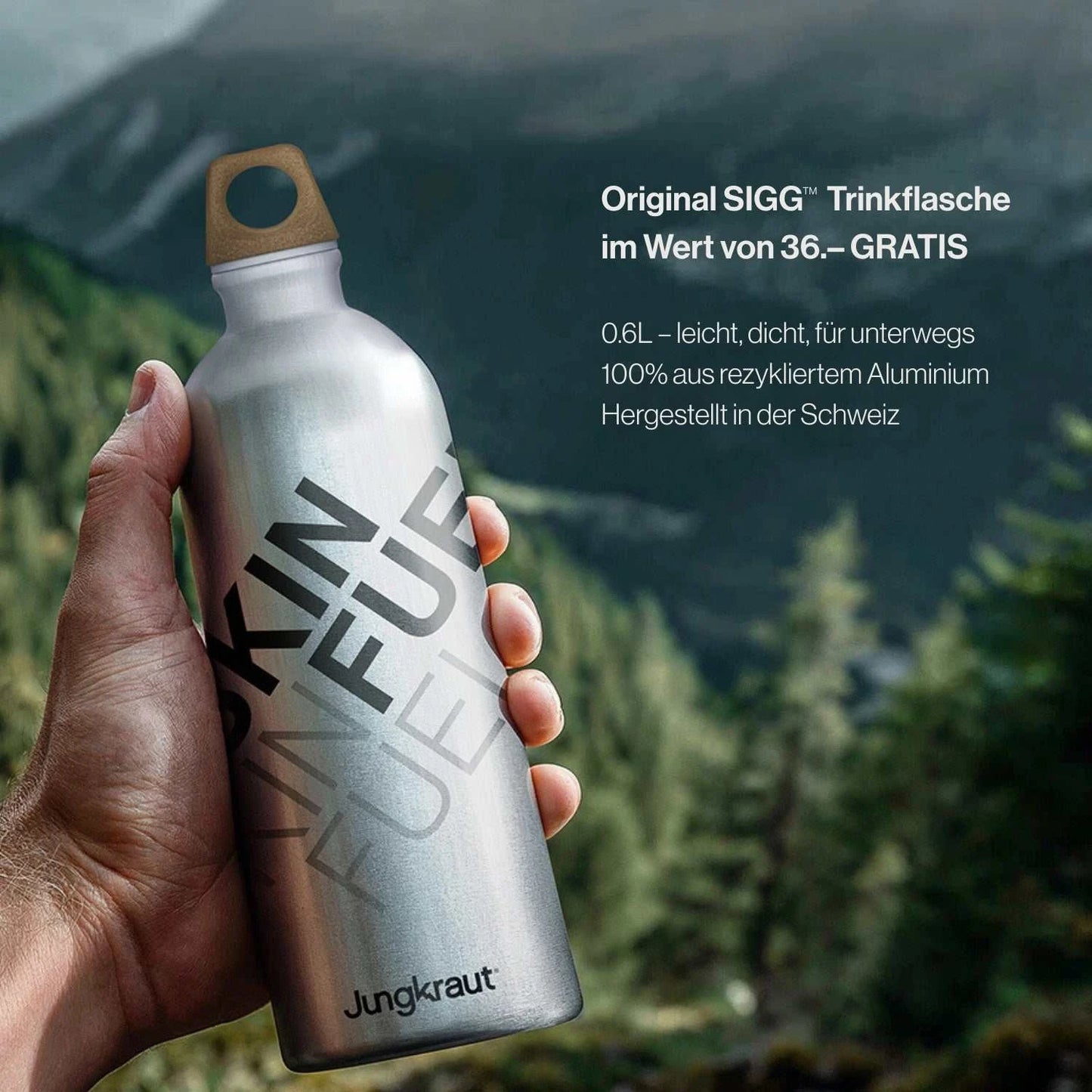 Hand hält eine silberne Jungkraut SIGG™ Trinkflasche mit der Aufschrift „SKIN FUEL“ vor alpiner Bergkulisse. Daneben steht: „Original SIGG™ Trinkflasche im Wert von 36.– GRATIS“. Die Flasche besteht aus 100 % recyceltem Aluminium, ist leicht, auslaufsicher und in der Schweiz hergestellt – Symbol für nachhaltige Qualität und Schweizer Präzision.