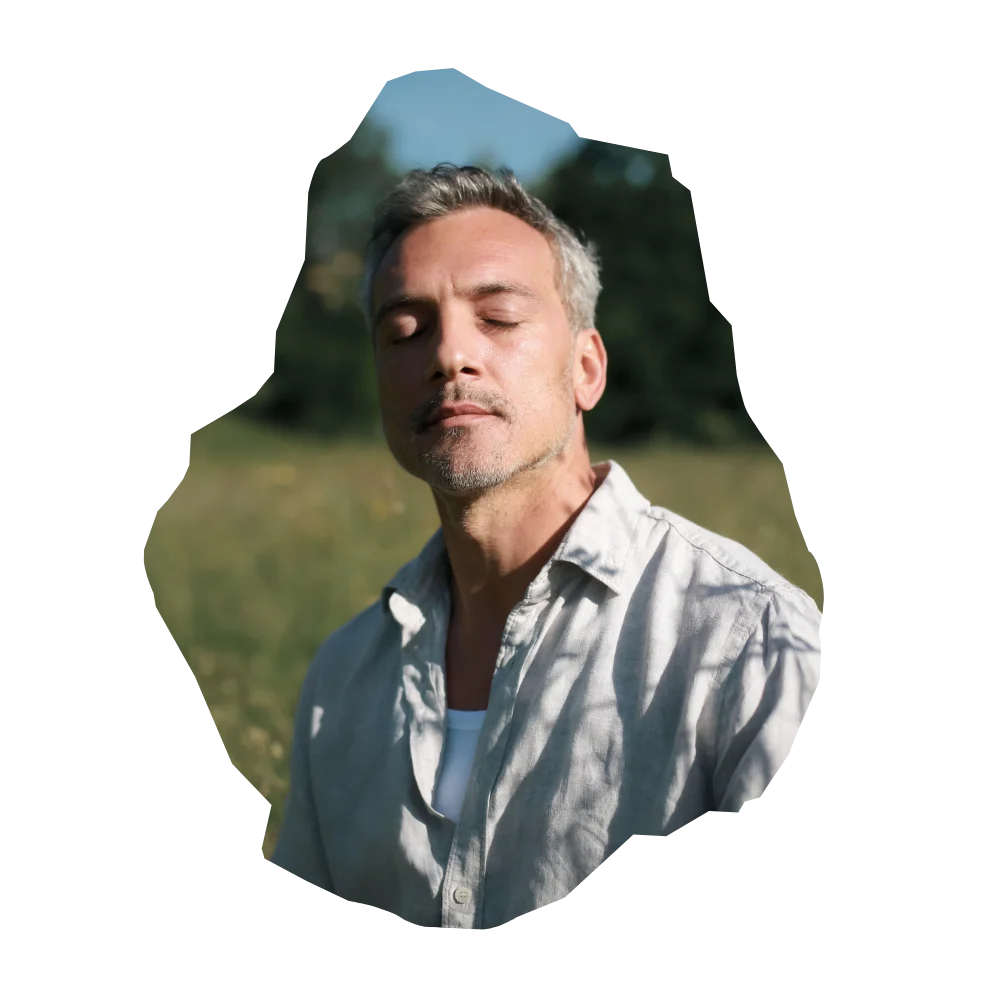 Mann mit geschlossenen Augen in natürlicher Wiese, entspanntes Motiv für Männerhautpflege