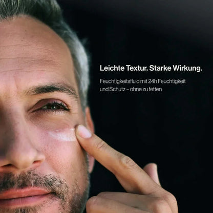 Mann trägt Jungkraut Gesichtspflege unter dem Auge auf.